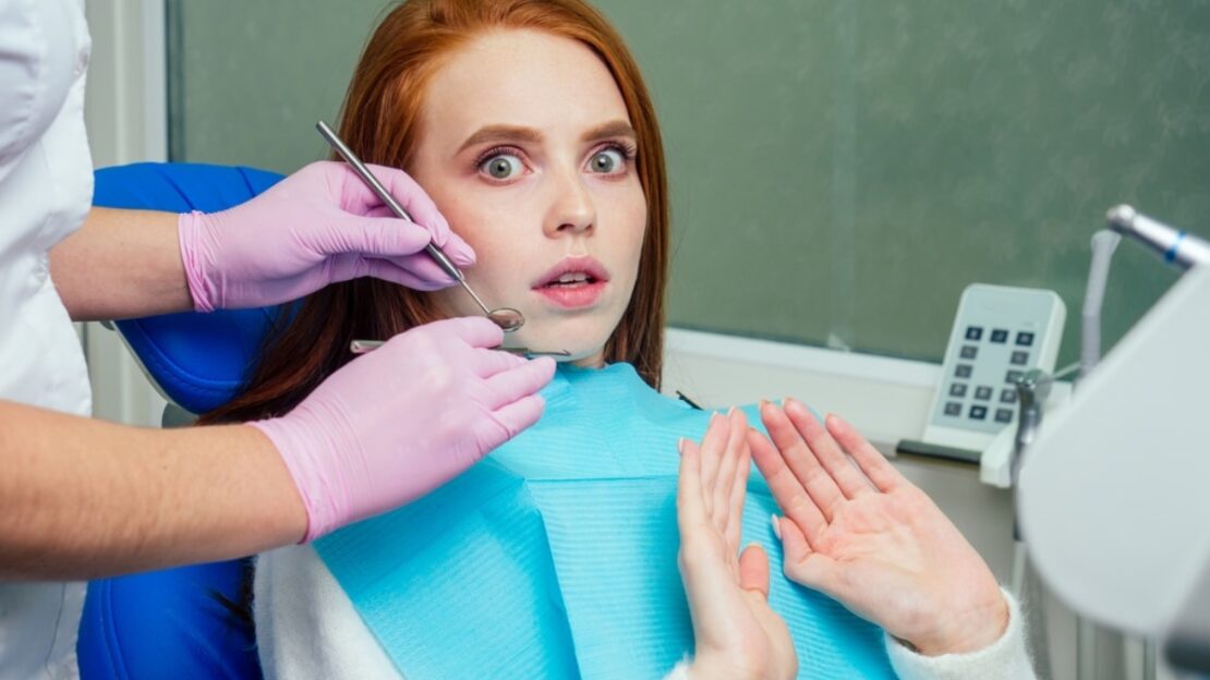 Anxious patient receiving dental examination from dentist in Snellville, GA.