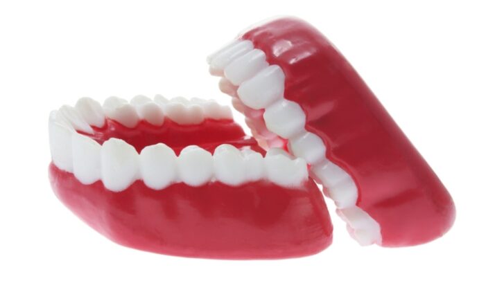 Properly fitted dentures showing upper and lower teeth alignment for quality dental care.