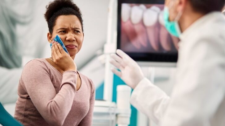Patient experiencing tooth pain consulting with dentist in Snellville dental office.
