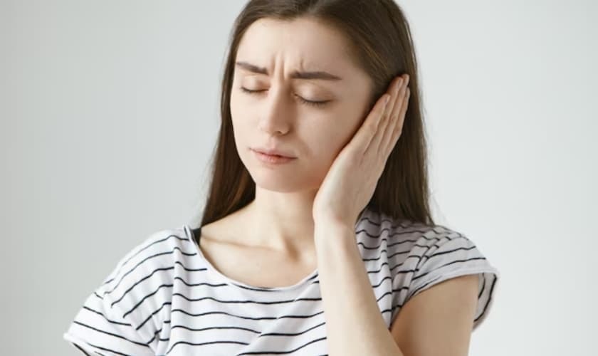 Woman holding her cheek in discomfort after tooth extraction in Snellville, GA.