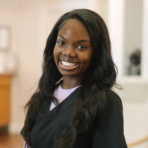 A'Mia, dental assistant at Snellville dental practice, smiling warmly in professional attire.
