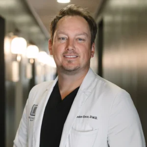 Dr. Brandon Esco, D.M.D. portrait in white coat at Snellville dental practice.