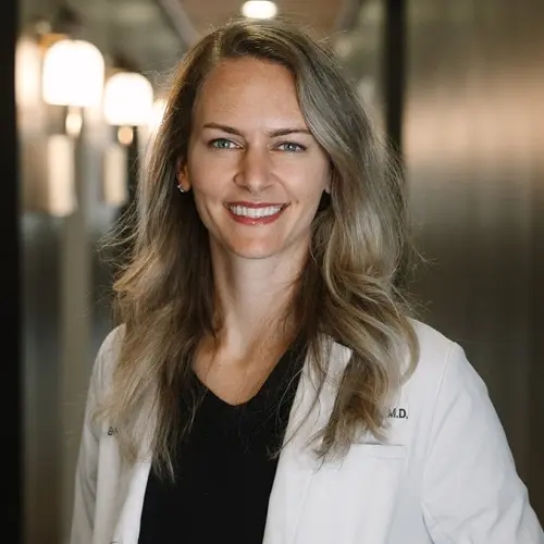 Dr. Jackie Janzen, D.M.D., smiling in professional white coat at Snellville dental practice.