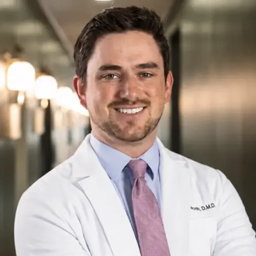Dr. Jon North, D.M.D. smiling in white coat and purple tie at dental practice in Snellville, GA.